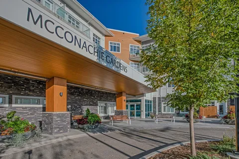 Residence entrance with a wood-clad canopy and landscaped walkway.