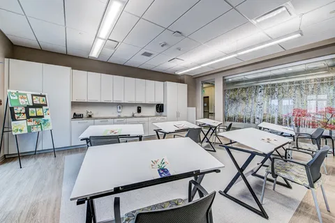 Activity room with tables, folding chairs and a kitchenette.