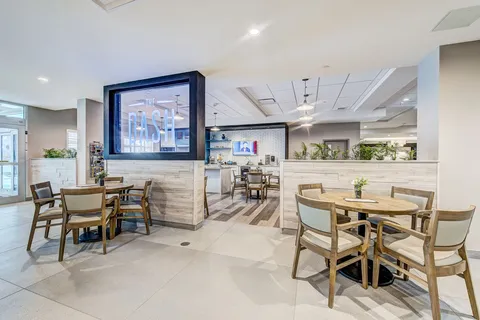 Bistro seating beside a counter and windows.