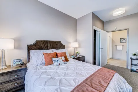 Bedroom with a bed, nightstand and window.