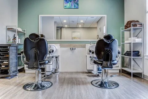 Salon with two styling chairs and mirrors.