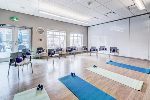 Exercise room with chairs, mats and small weights.