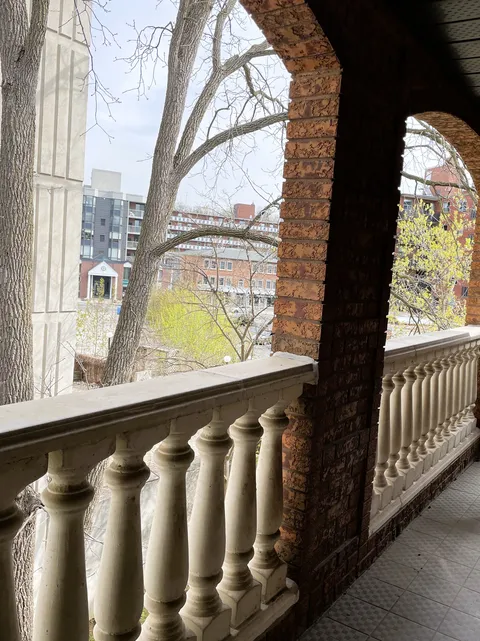 Covered veranda with brick arches and a stone balustrade.