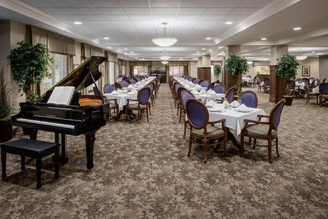 Dining room with rows of set tables and a grand piano