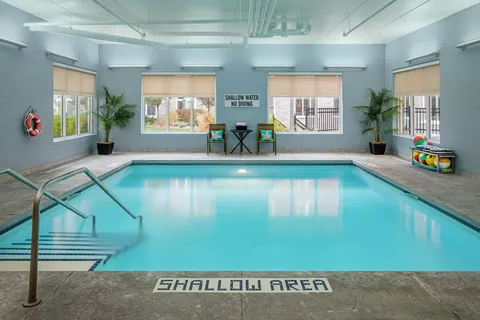 Indoor swimming pool with steps, handrails and large windows