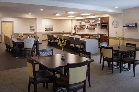 Dining area with tables beside an open kitchen counter.