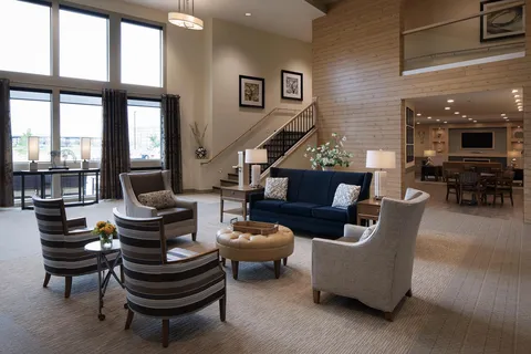 Lobby seating beside tall windows and a fireplace.