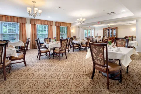 Dining room with set tables, upholstered chairs and chandeliers