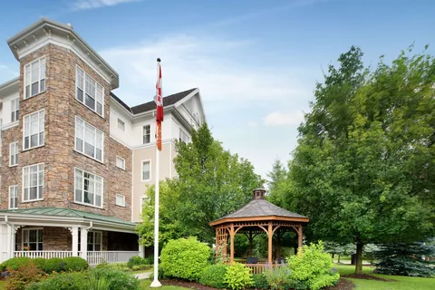 Residence exterior beside a gazebo, trees and a Canadian flag