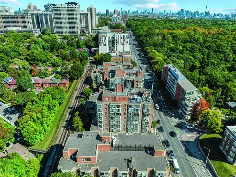 Aerial view of multi-storey residence buildings beside a wooded park