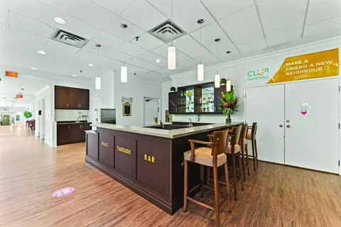Bar counter with tall stools and a glass-front cabinet