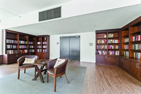 Library with bookshelves, two armchairs and a small table