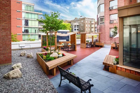 Courtyard with raised planting beds, wooden seating and a gazebo