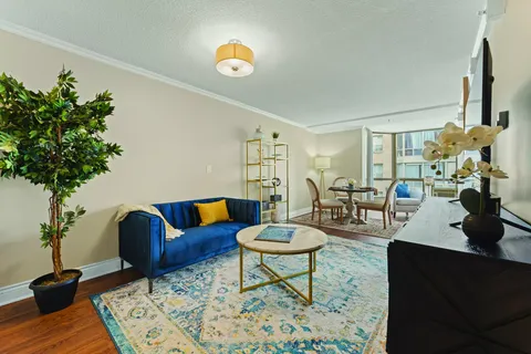 Sitting area with a blue sofa, round coffee table and dining table