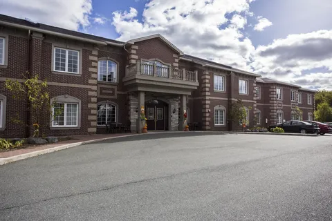 Residence exterior with brick walls, balconies and front parking.