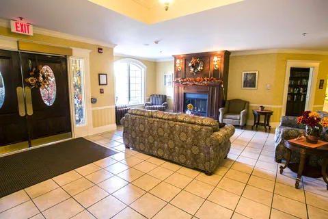 Entrance lounge with sofas, tiled floor and glass doors.