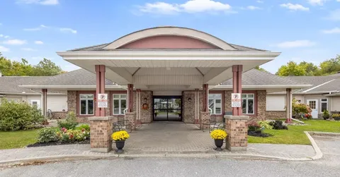 Covered entrance with brick columns, glass doors and yellow flower planters