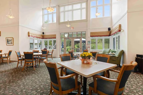 Room with tables, chairs, tall windows and doors to an outdoor patio