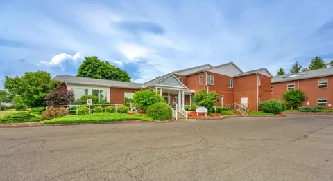Brick residence building with a covered entrance and landscaped beds