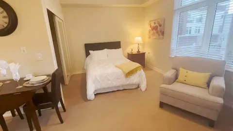 Studio suite with a bed, sofa, table and kitchenette.