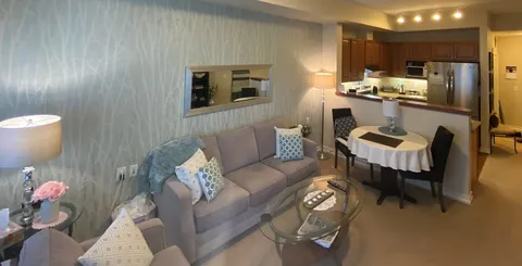 Suite sitting room with a sofa, dining table and open kitchen.