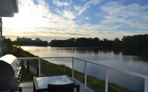 Balcony railing overlooking a river at sunset