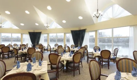 Dining room with set tables and wide windows overlooking the river