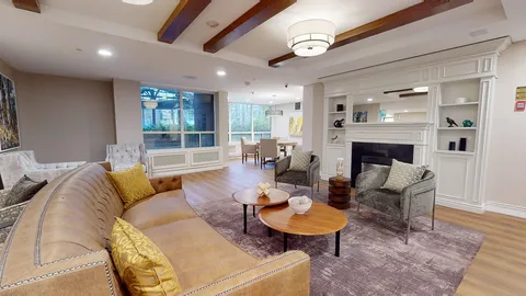 Lounge with sofas, armchairs, ceiling beams and a fireplace.