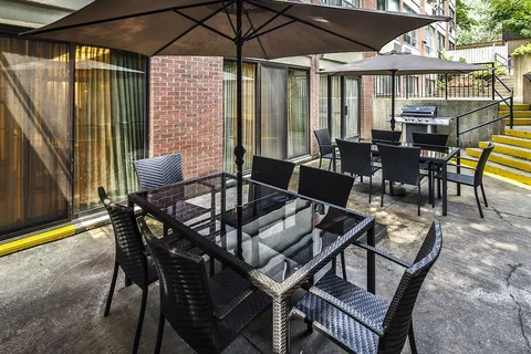 Patio with chairs and tables beneath umbrellas.