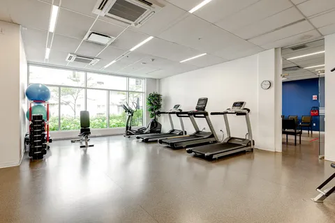 Fitness room with treadmills, a cycle, weights and large windows