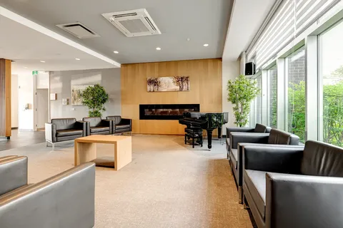 Lounge with leather chairs, a grand piano, fireplace and broad windows