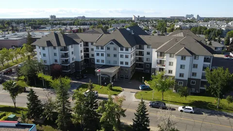 Multi-storey residence with pitched roofs, trees and a front driveway