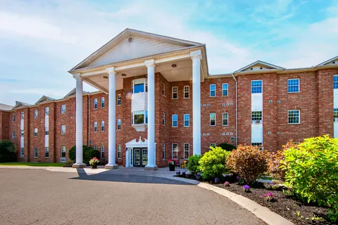 Colonial residence with a red-brick façade and tall white entrance columns.