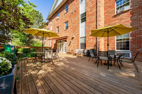 Wooden deck beside the building with patio tables and green umbrellas.