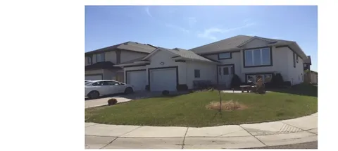 Two-storey residence with an attached garage, a front lawn and a parked car