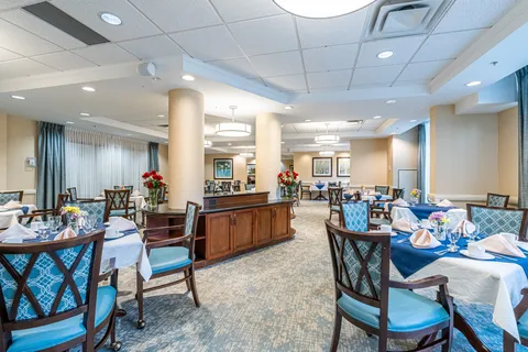 Dining room with blue upholstered chairs, set tables and cream columns