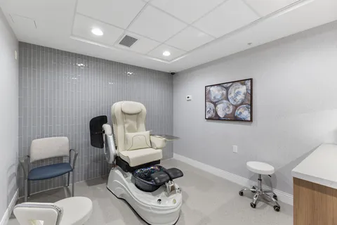 Room with a pedicure chair, foot bath and blue side chair