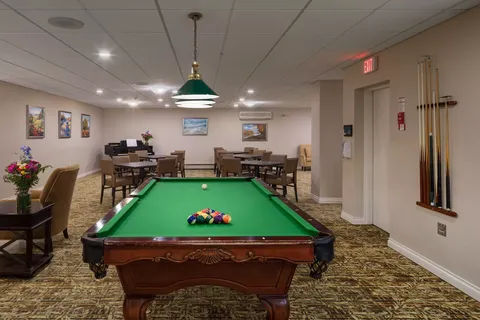 Games room with a pool table, card tables and framed artwork