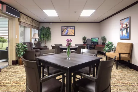 Room with tables, armchairs, a computer and framed bird artwork