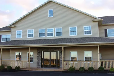 Covered entrance with glass doors, stone trim and a wooden porch