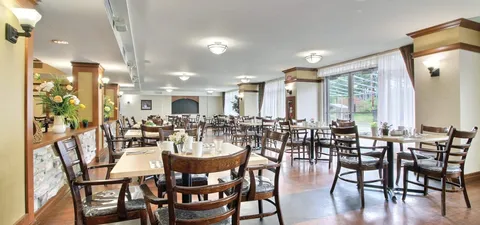 Dining room with wooden tables, chairs and large windows