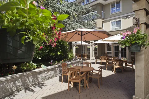 Courtyard with tables, chairs, umbrellas and hanging flower baskets