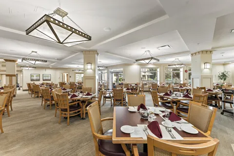 Dining room with wooden tables, chairs and square pendant lights