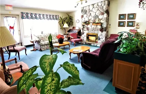 Lounge with stone fireplace, armchairs and large windows