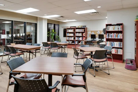 Room with tables, chairs, bookshelves and desktop computers