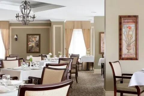 Dining room with upholstered chairs and set tables.