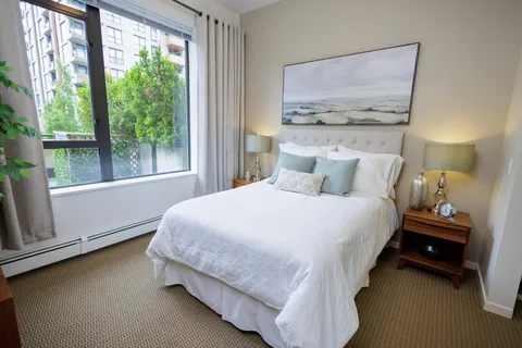 Bedroom with a large bed, white bedding and a landscape picture