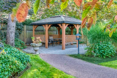 Garden path leading to a gazebo among lawns and trees