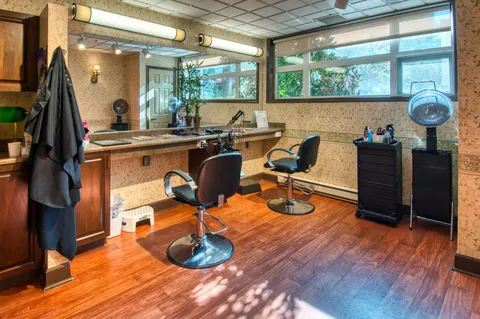 Salon with styling chairs, mirrors and a hair-washing sink