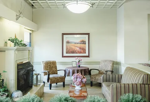 Lounge with sofas, armchairs, a fireplace and windows.